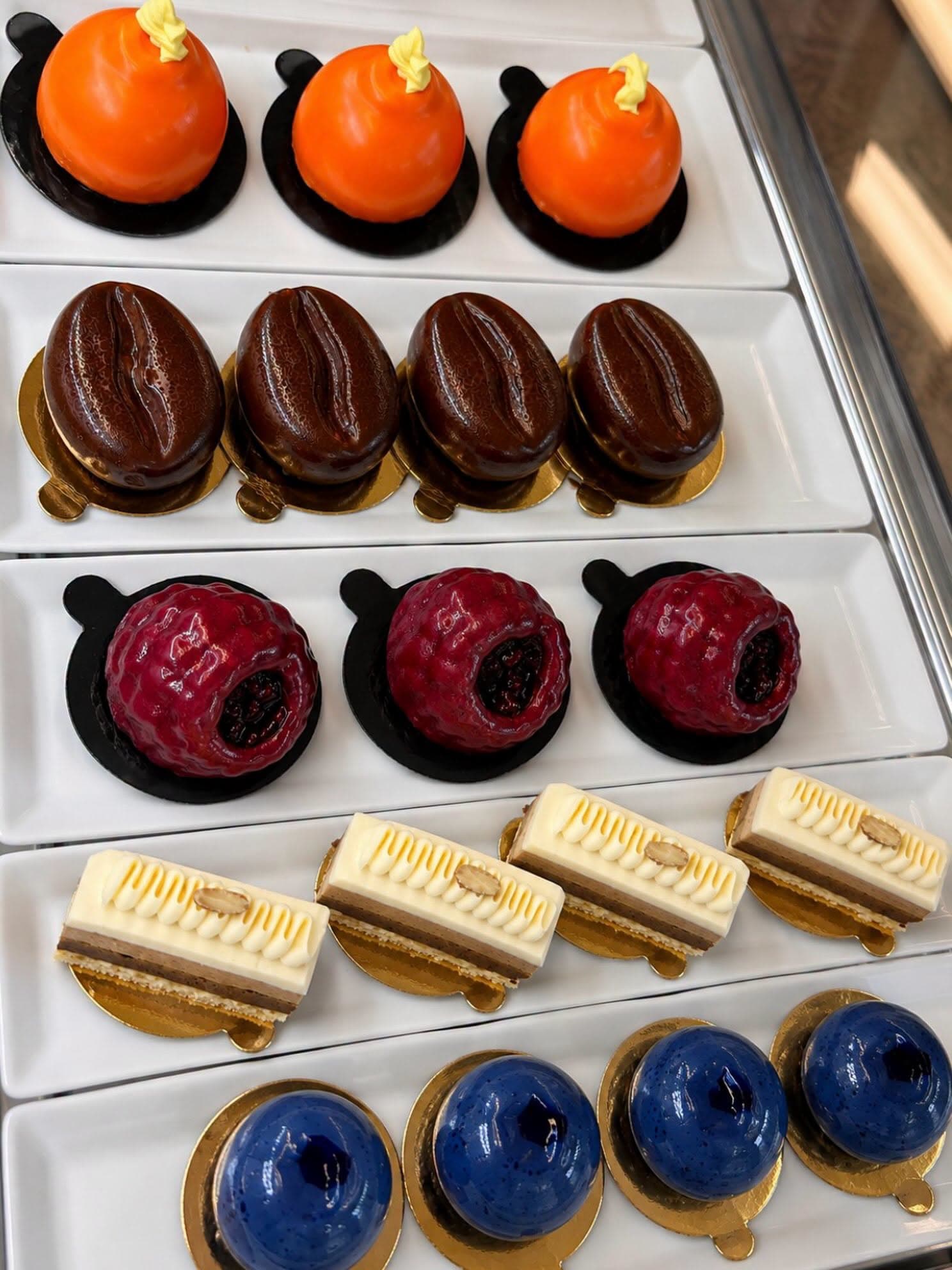 Orange, raspberry and blueberry desserts displayed in the bakery’s pastry case